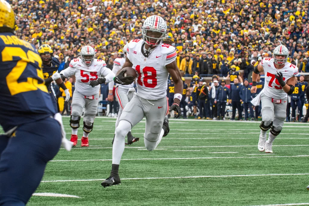 ANN ARBOR, MICHIGAN - NOVEMBER 25: Marvin Harrison Jr. #18 of the Ohio State Buckeyes runs with the ball for a touchdown during the second half of a college football game against the Michigan Wolverines at Michigan Stadium on November 25, 2023 in Ann Arbor, Michigan. The Michigan Wolverines won the game 30-24 to win the Big Ten East.
