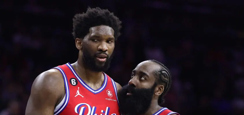 PHILADELPHIA, PENNSYLVANIA - DECEMBER 23: Joel Embiid #21 and James Harden #1 of the Philadelphia 76ers speak during the fourth quarter against the LA Clippers at Wells Fargo Center on December 23, 2022 in Philadelphia, Pennsylvania.