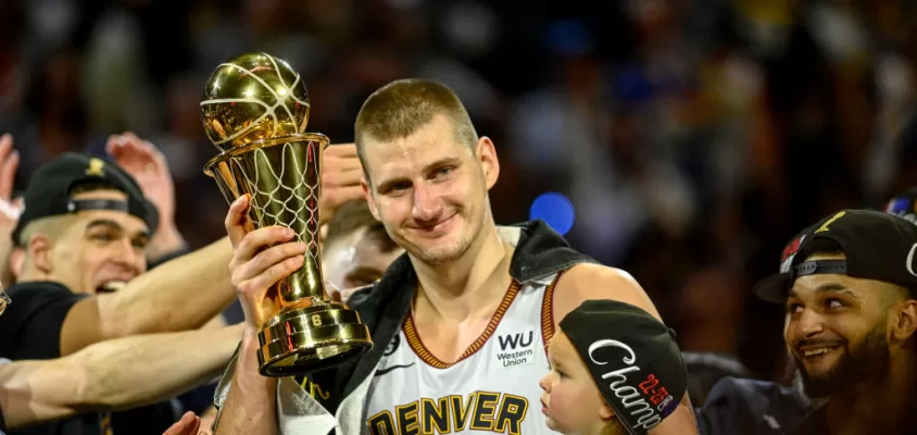 DENVER, CO - JUNE 12: Nikola Jokic (15) of the Denver Nuggets displays the NBA Finals Most Valuable Player Award as the star holds his daughter, Ognjena, after the fourth quarter of the Nuggets' 94-89 NBA Finals clinching win over the Miami Heat at Ball Arena in Denver on Monday, June 12, 2023.