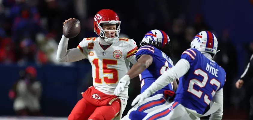 ORCHARD PARK, NEW YORK - JANUARY 21: Patrick Mahomes #15 of the Kansas City Chiefs dodges Micah Hyde #23 of the Buffalo Bills during their AFC Divisional Playoff game at Highmark Stadium on January 21, 2024 in Orchard Park, New York.