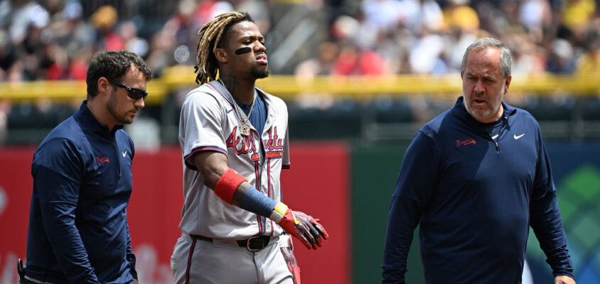 PITTSBURGH, PENNSYLVANIA - MAY 26: Ronald Acuña Jr. #13 of the Atlanta Braves walks off the field with trainers after an apparent injury in the first inning during the game against the Pittsburgh Pirates at PNC Park on May 26, 2024 in Pittsburgh, Pennsylvania